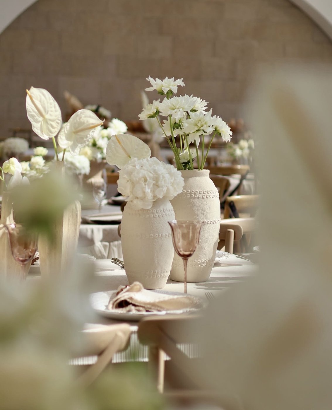 Table dressée avec vases en céramique et fleurs blanches, mariage en Israël